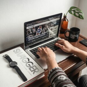 A person working on a laptop at a desk with a watch and mug, perfect for a productivity concept.